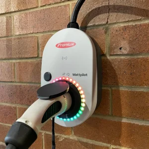 Fronius EV charger on brick wall.